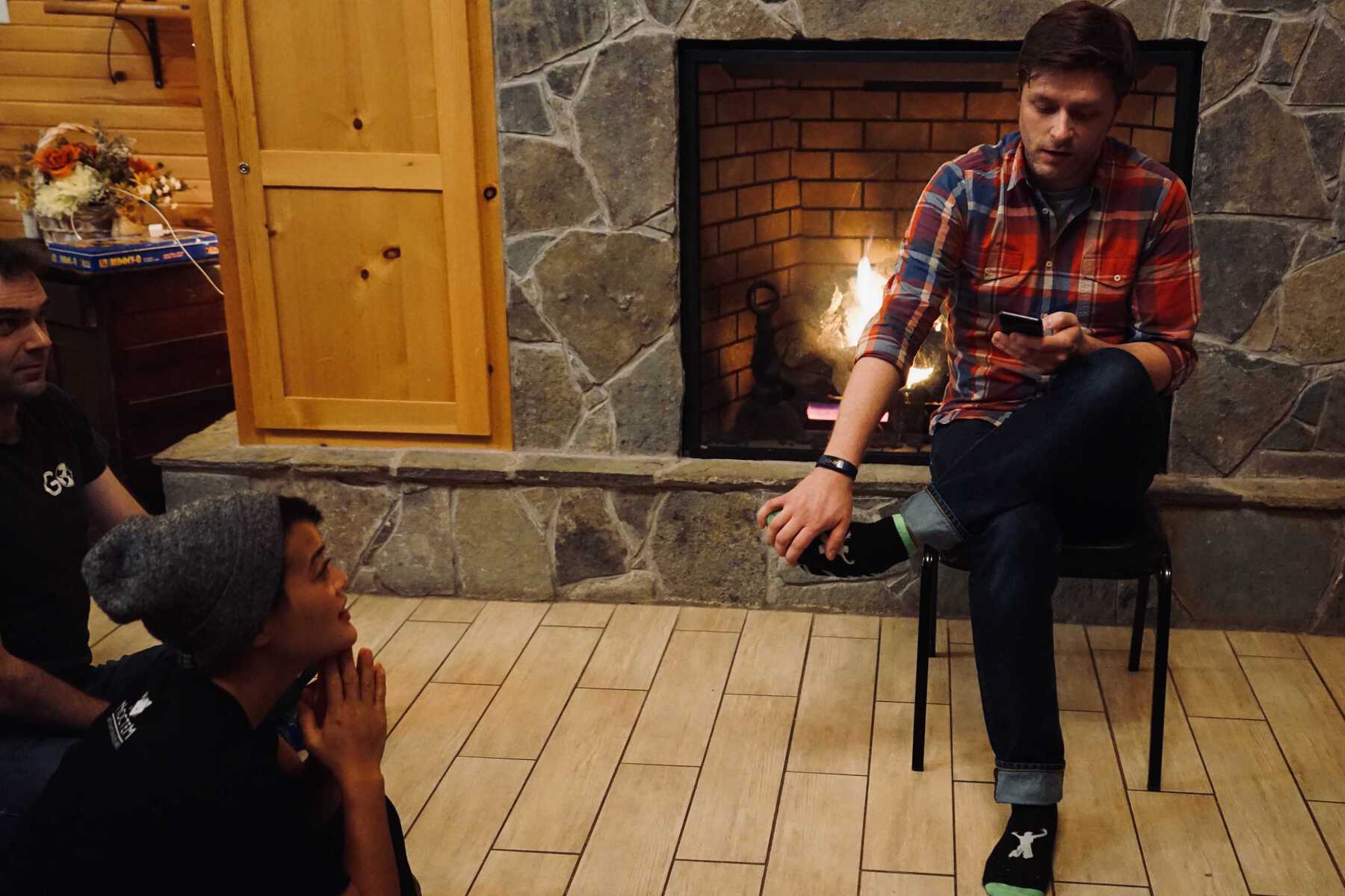 Man reading to a group in front of fireplace