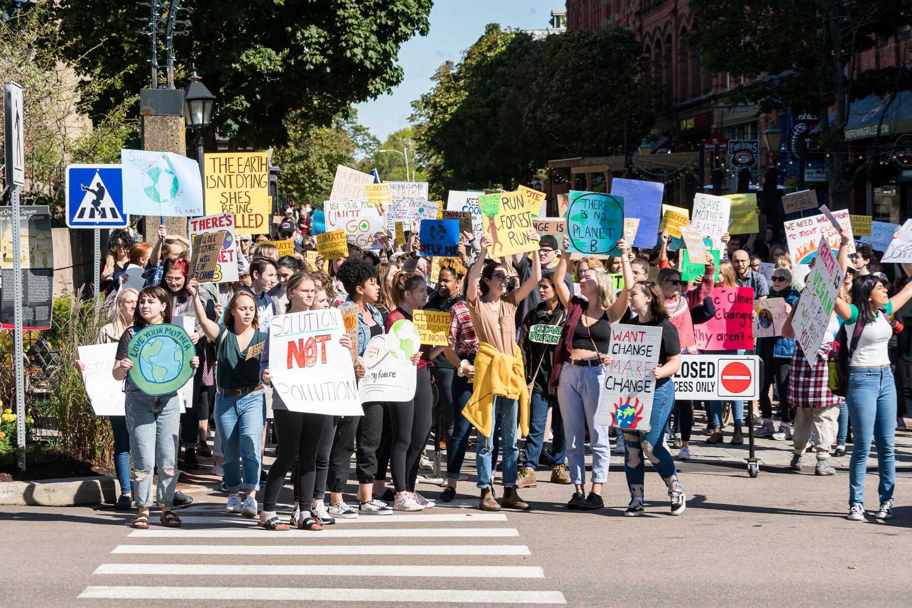 Crowd of protesters with signs crossing road