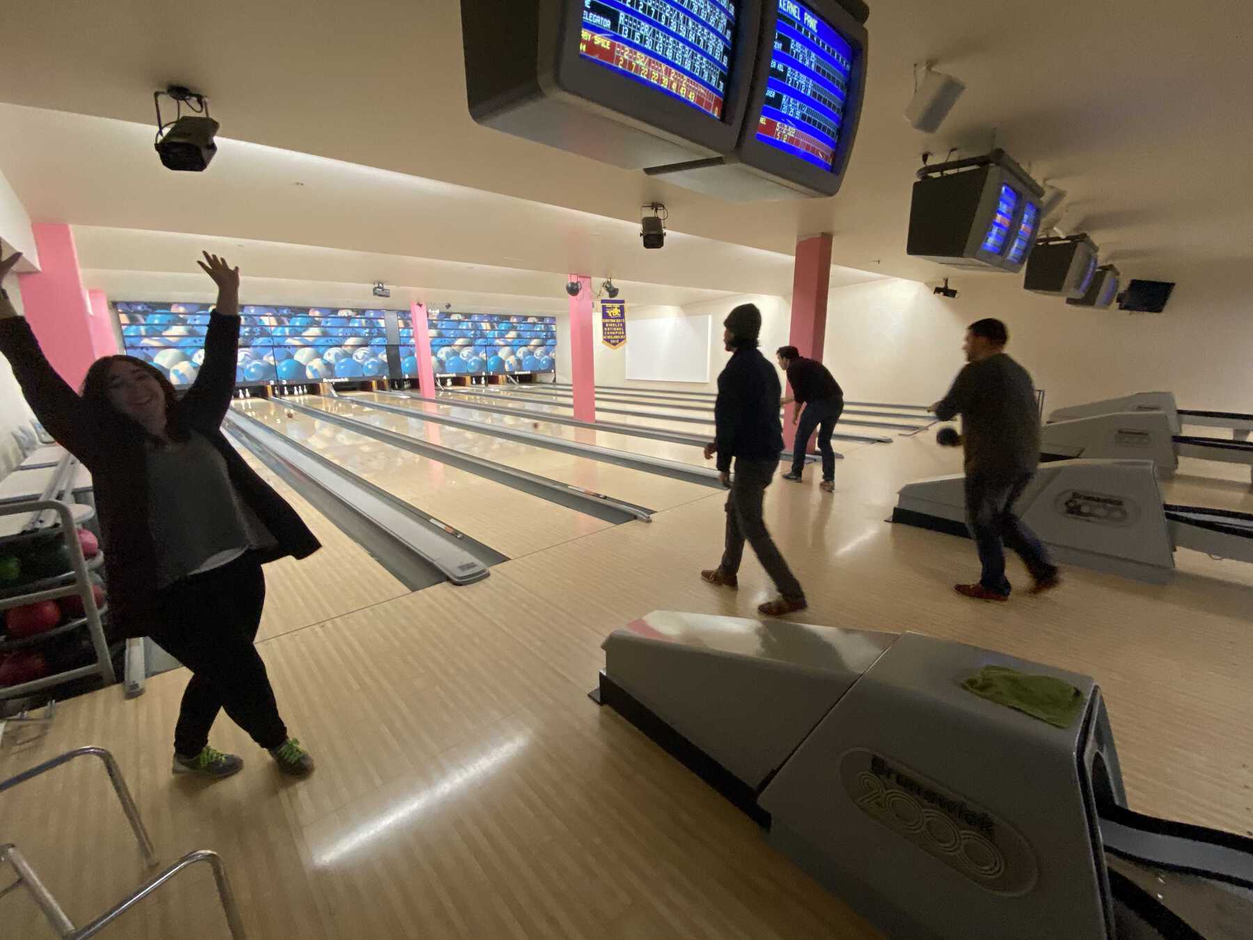 Woman with hands raised on bowling alley