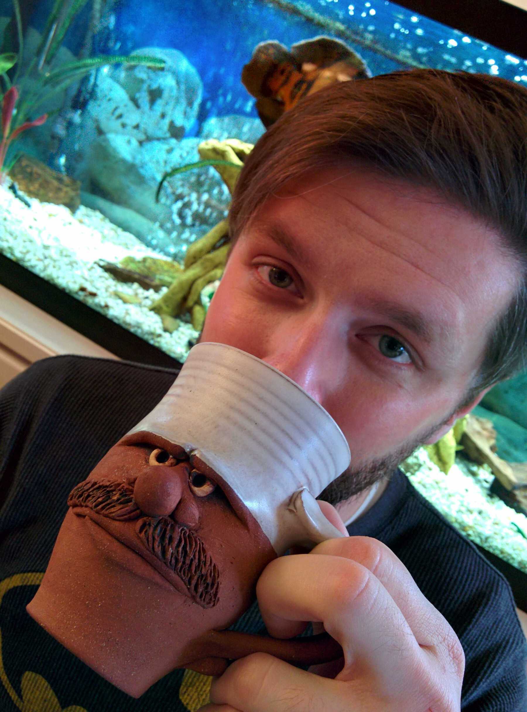 Man drinking from coffee mug with mustache and frowning face