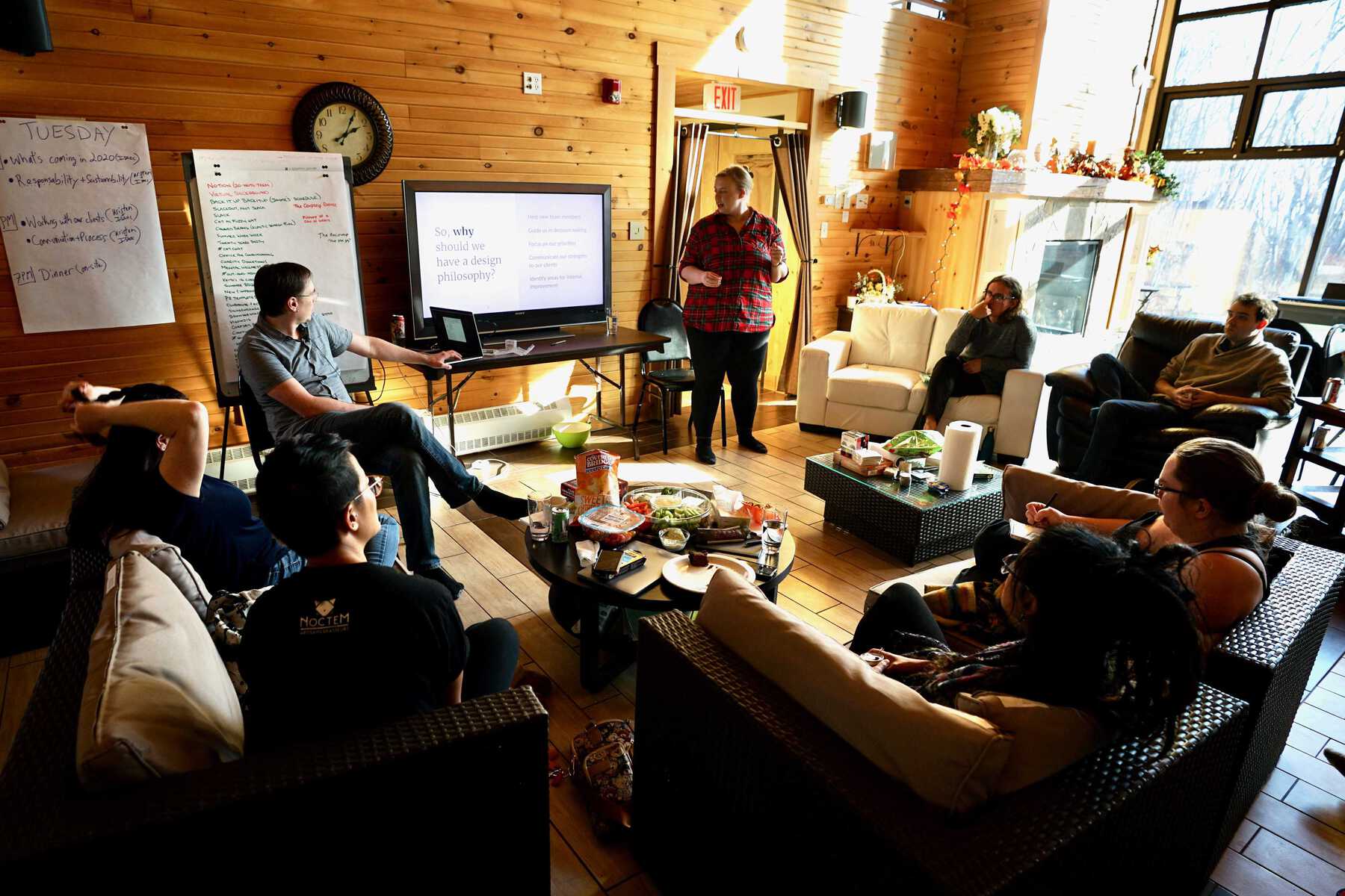 Woman giving presentation to group of people on couches