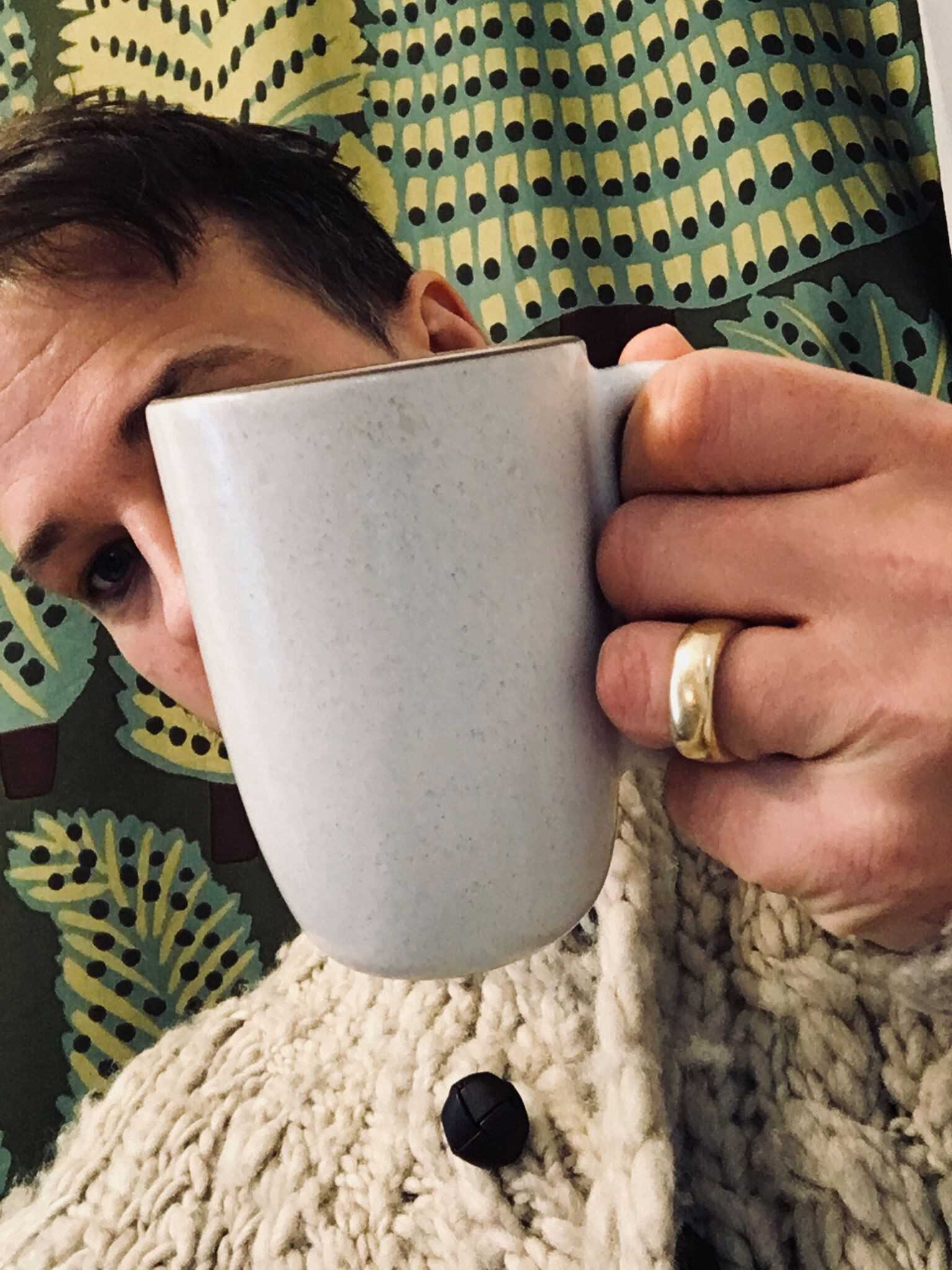 Man holding up ceramic mug